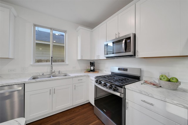 kitchen featuring white cabinetry, stainless steel appliances, a sink, and dark wood-type flooring