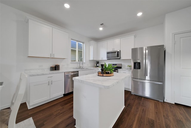 16322 Fontana Ct, Conroe, TX 77302 - kitchen featuring stainless steel appliances, a sink, dark wood finished floors, white cabinets, and light countertops