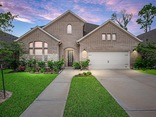 16926 Grayson Woods Ln, Humble, TX 77346 - french country inspired facade featuring brick siding, a front lawn, an attached garage, and driveway