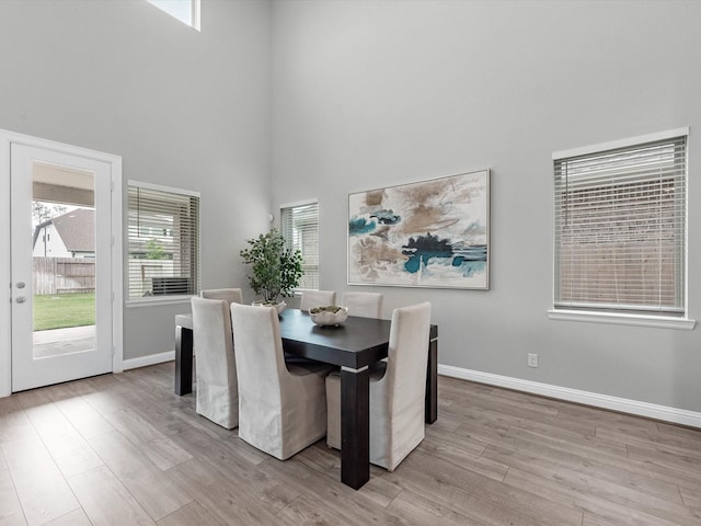 16926 Grayson Woods Ln, Humble, TX 77346 - dining space with baseboards, light wood finished floors, and a towering ceiling