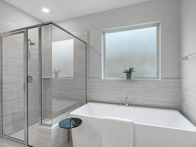 16926 Grayson Woods Ln, Humble, TX 77346 - bathroom with a freestanding tub, tile walls, and a stall shower