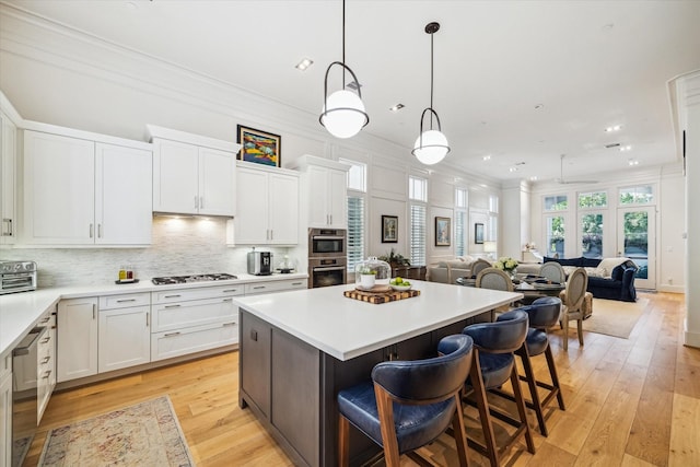 kitchen with gas cooktop, light countertops, open floor plan, and a center island