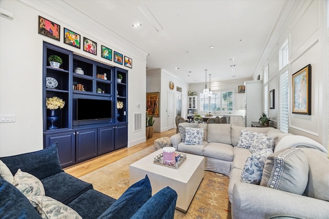 living room featuring light wood-type flooring, recessed lighting, crown molding, and visible vents
