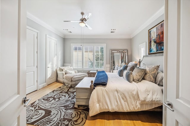 bedroom featuring ornamental molding, a ceiling fan, wood finished floors, and visible vents