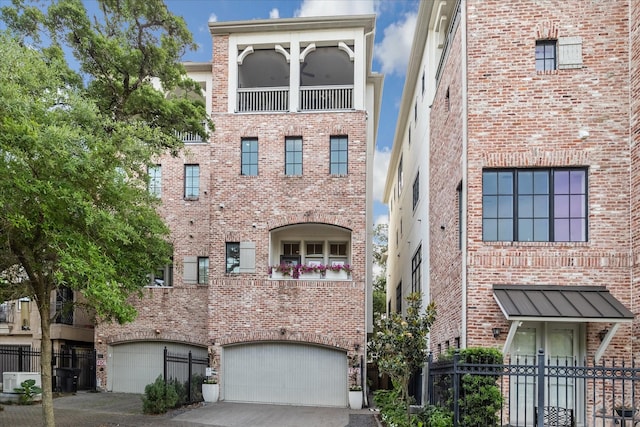 view of property with fence, an attached garage, and driveway