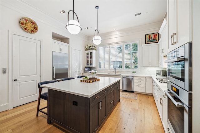 kitchen featuring a sink, light countertops, white cabinets, and stainless steel appliances