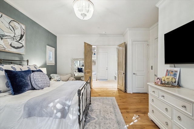 bedroom with ornamental molding and light wood finished floors