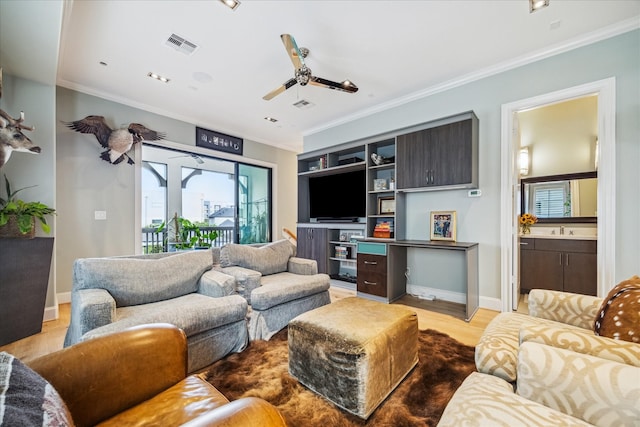 living room featuring crown molding, light wood-style floors, a ceiling fan, baseboards, and visible vents