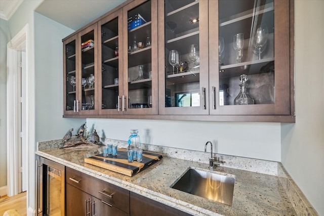 bar with indoor wet bar, a sink, and wine cooler