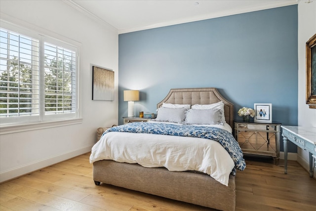 bedroom featuring crown molding, baseboards, and wood-type flooring