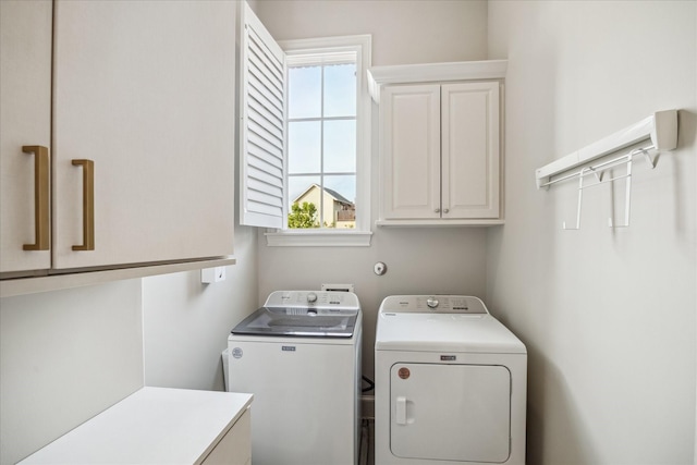 washroom featuring cabinet space and washing machine and clothes dryer