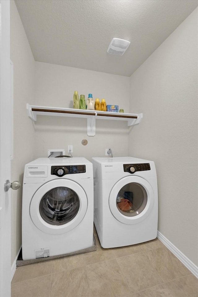 11417 Hackmatack Way, Houston, TX 77066 - washroom featuring washer and dryer, baseboards, a textured ceiling, and light tile patterned flooring