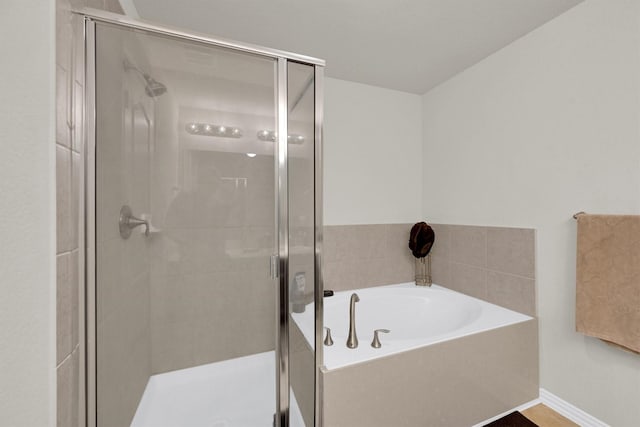 11417 Hackmatack Way, Houston, TX 77066 - bathroom with a bath, a shower stall, and baseboards