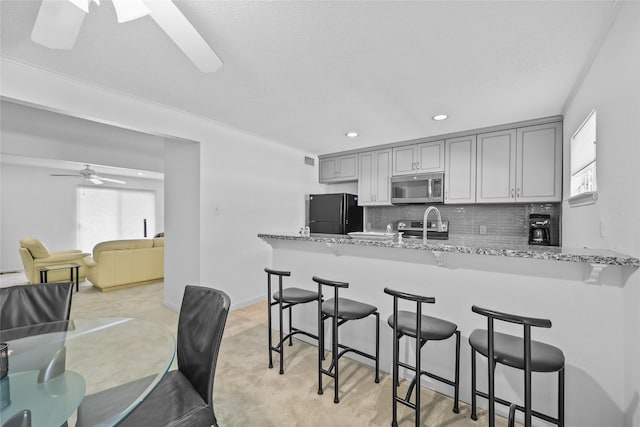 kitchen featuring plenty of natural light, a kitchen breakfast bar, stainless steel appliances, and a peninsula