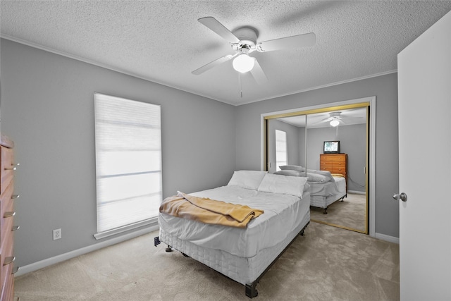 bedroom featuring a closet, carpet flooring, a textured ceiling, and a ceiling fan
