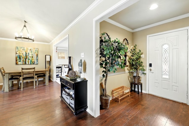 foyer entrance with crown molding, dark wood-style flooring, baseboards, and a chandelier