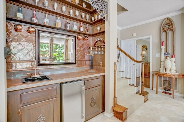 bar featuring wet bar, fridge, baseboards, ornamental molding, and stairs