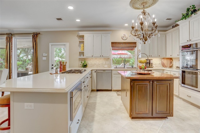 kitchen featuring visible vents, light countertops, appliances with stainless steel finishes, and a kitchen island