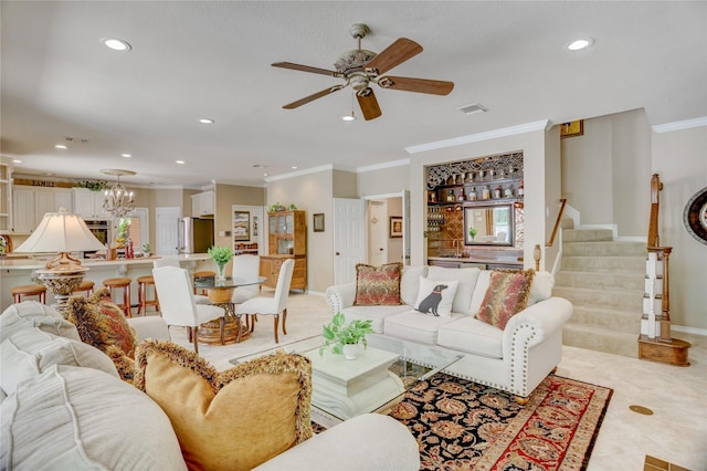 living room with crown molding, ceiling fan with notable chandelier, recessed lighting, visible vents, and stairway