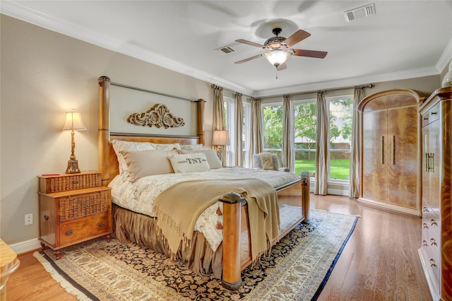 bedroom featuring visible vents, ornamental molding, and light wood-style floors