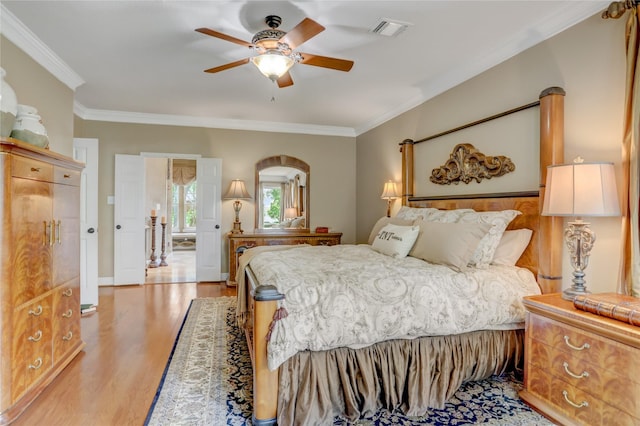 bedroom with ornamental molding, a ceiling fan, light wood-type flooring, and visible vents