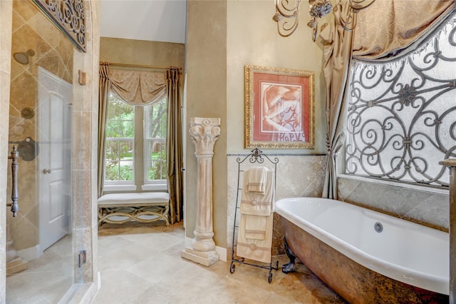 full bathroom with tile walls, a freestanding bath, and a shower stall