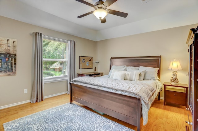 bedroom with baseboards, ceiling fan, and light wood-type flooring
