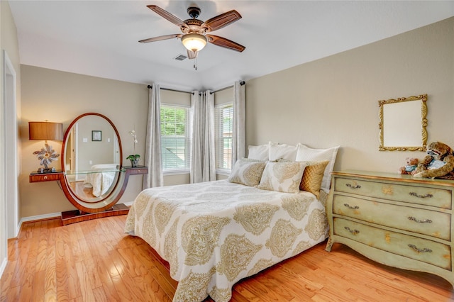 bedroom featuring baseboards, ceiling fan, light wood-type flooring, and visible vents
