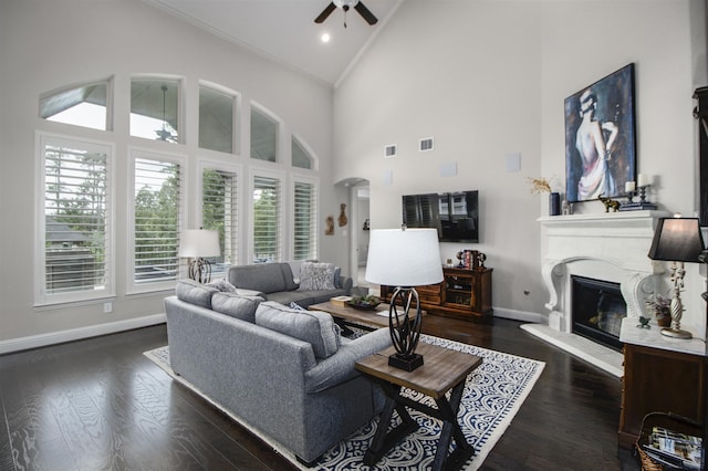 34119 Mill Creek Way, Pinehurst, TX 77362 - living area featuring crown molding, high vaulted ceiling, a glass covered fireplace, a ceiling fan, and baseboards