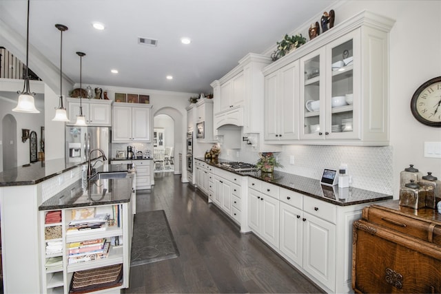 34119 Mill Creek Way, Pinehurst, TX 77362 - kitchen with visible vents, crown molding, arched walkways, appliances with stainless steel finishes, and a sink