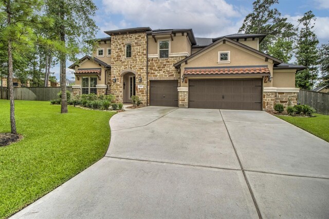 34119 Mill Creek Way, Pinehurst, TX 77362 - view of front of property with a front lawn, fence, stone siding, stucco siding, and concrete driveway