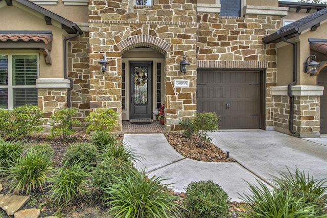 34119 Mill Creek Way, Pinehurst, TX 77362 - entrance to property featuring an attached garage, stucco siding, concrete driveway, and stone siding