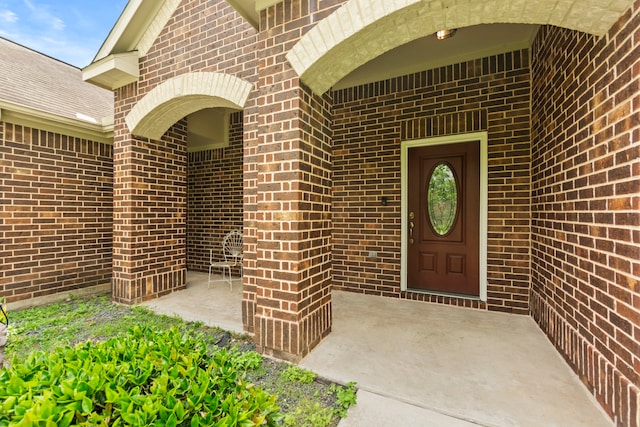 entrance to property featuring brick siding