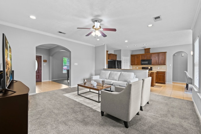 living room with arched walkways, ceiling fan, and visible vents