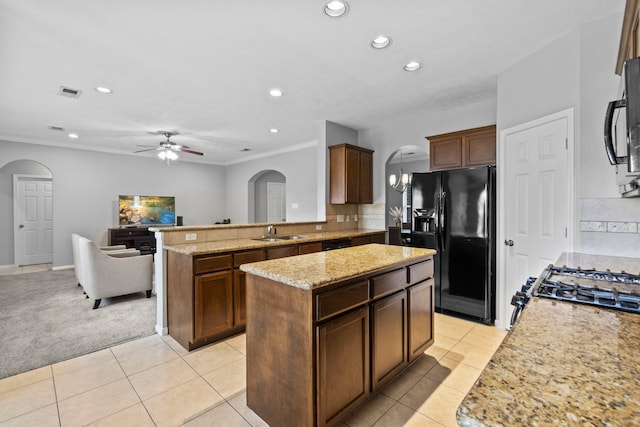 kitchen featuring arched walkways, recessed lighting, a sink, and black appliances