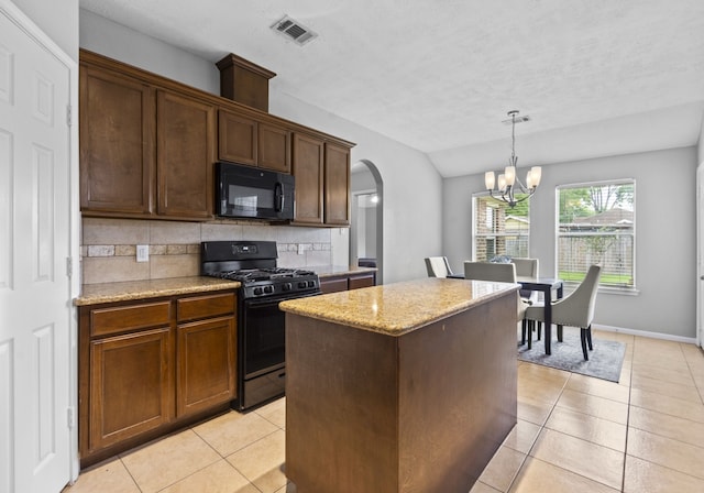 kitchen featuring light tile patterned flooring, arched walkways, tasteful backsplash, visible vents, and black appliances