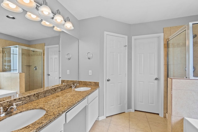 bathroom with a sink, tile patterned floors, a shower stall, and a garden tub