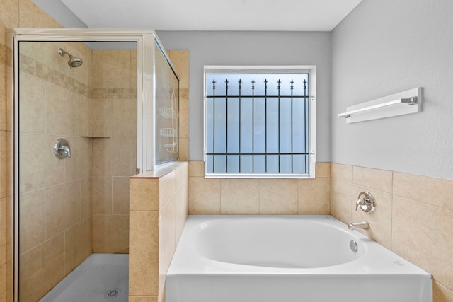 full bathroom with a bath and a stall shower
