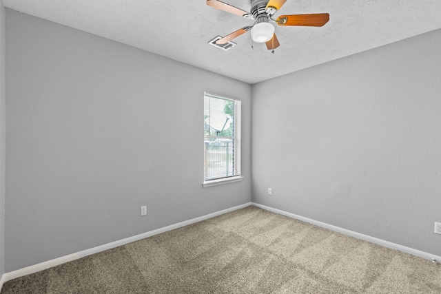 carpeted spare room with baseboards, ceiling fan, a textured ceiling, and visible vents
