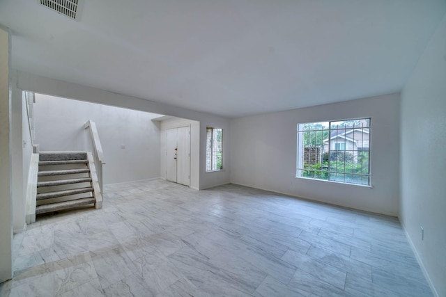 unfurnished living room featuring stairway, marble finish floor, and visible vents
