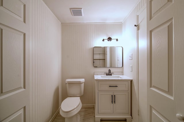 bathroom featuring visible vents, toilet, and vanity