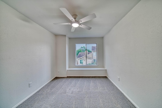 unfurnished room featuring carpet floors, a textured wall, ceiling fan, and baseboards