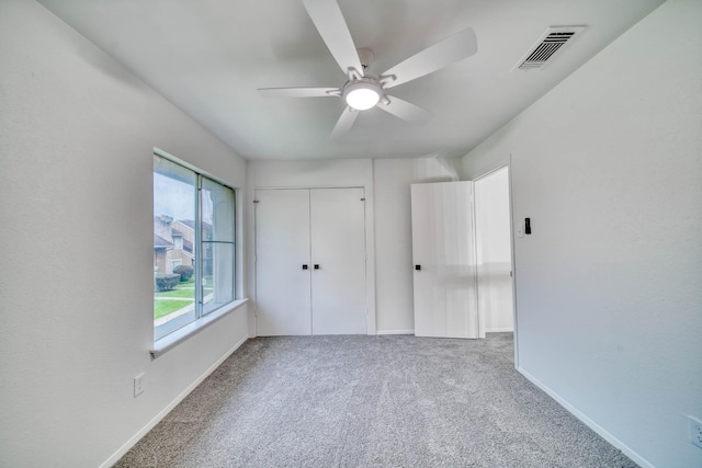 unfurnished bedroom featuring visible vents, a closet, baseboards, ceiling fan, and carpet