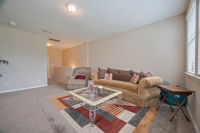 carpeted living area featuring baseboards and visible vents