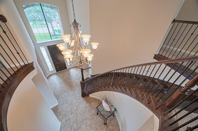 entrance foyer with a high ceiling, a chandelier, and stairway