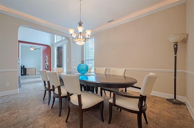 dining room with visible vents, crown molding, baseboards, arched walkways, and a notable chandelier