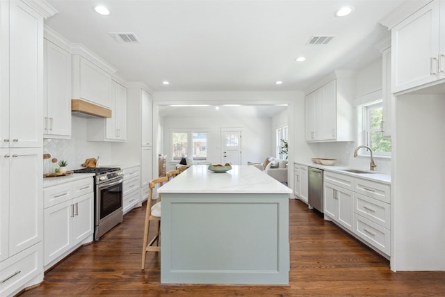 1026 Fugate St, Houston, TX 77009 - kitchen with appliances with stainless steel finishes, a sink, a center island, white cabinets, and recessed lighting