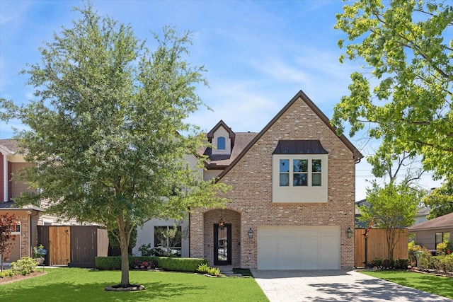 view of front facade with fence, driveway, and brick siding