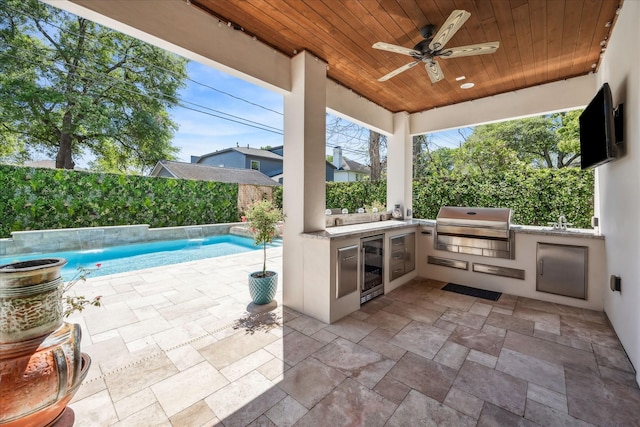 view of patio with a fenced backyard, area for grilling, a ceiling fan, exterior kitchen, and wine cooler