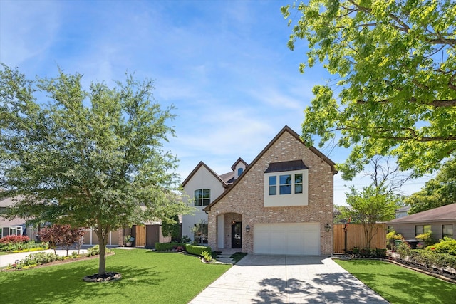 traditional-style house with fence, a front lawn, brick siding, a garage, and driveway